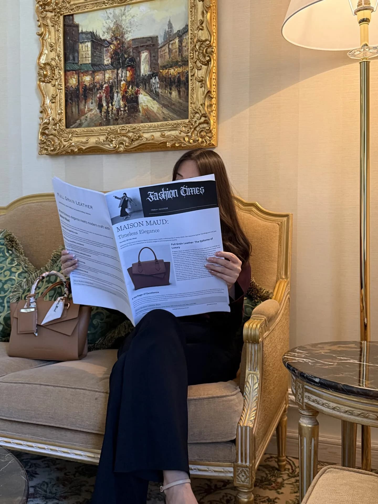 Woman reading Fashion Times Maison Maud feature in hotel lounge